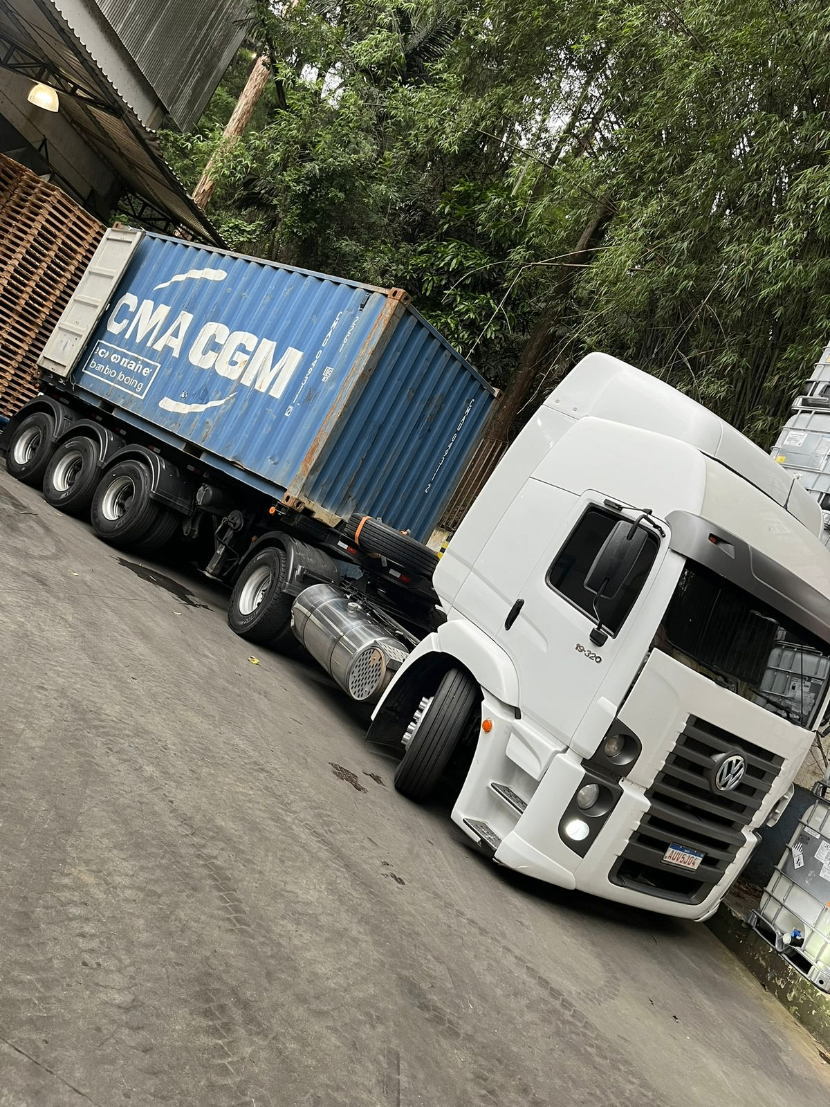 Caminhão branco da MRS Transportes transportando container azul