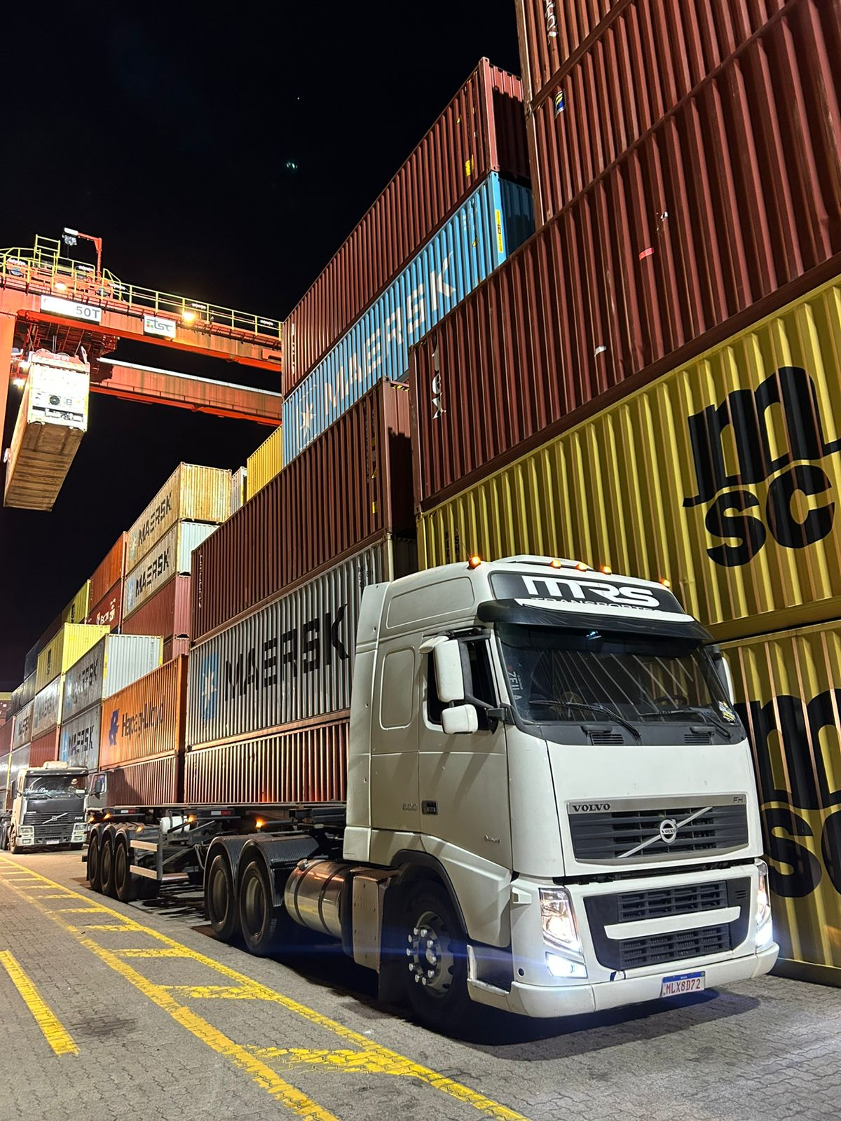 Caminhão da MRS Transportes em terminal de containers durante a noite